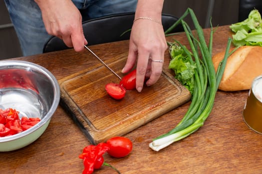 Chop the green onions and tomatoes and place them in a bowl. Prepare the salad.