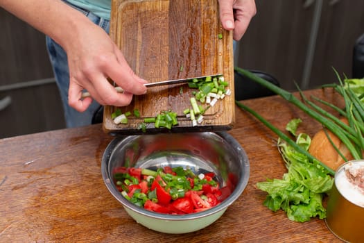 Chop the green onions and tomatoes and place them in a bowl. Prepare the salad.