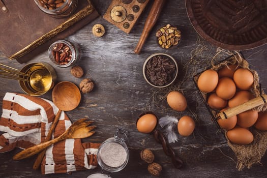 Assorted baking ingredients on wooden vintage table, in brown tone
