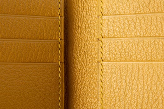 Part of a yellow leather wallet business card holder close-up.