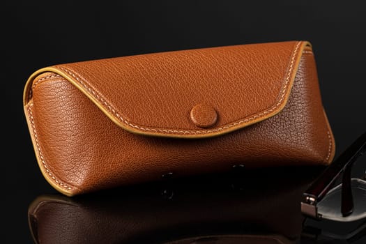 Glasses with leather case on a black background.