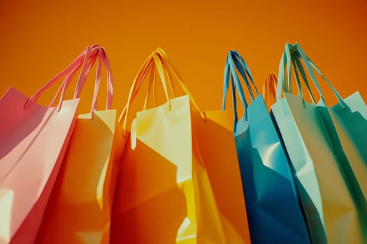 Brightly colored shopping bags in pink, yellow, and blue arranged against an orange backdrop create a vibrant display.