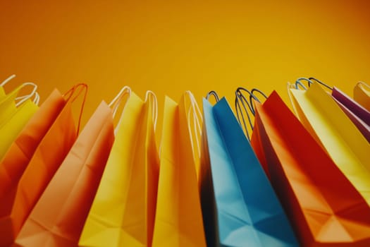 Brightly colored paper bags are arranged in a row against a warm yellow background, creating a vibrant display perfect for shopping.