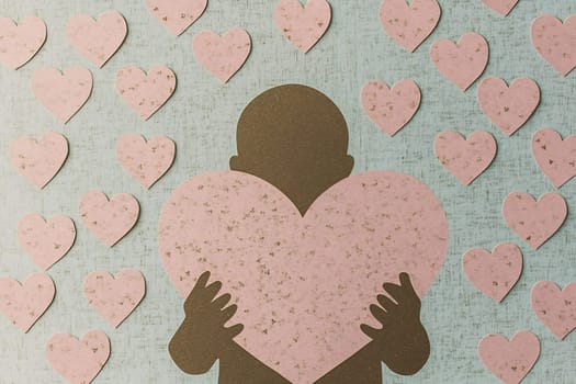 A silhouette of a person holds a large pink heart, surrounded by various smaller heart shapes on a textured background.