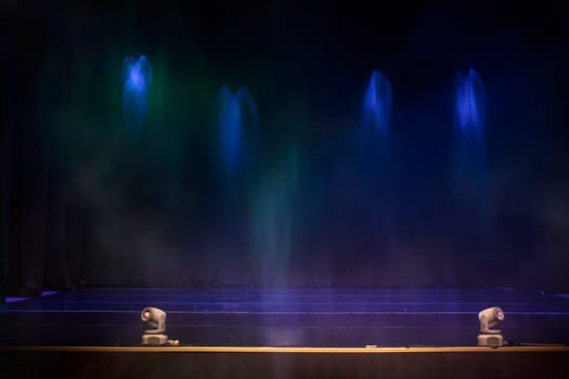 Empty retro wall background with blue rays of light and smoke.