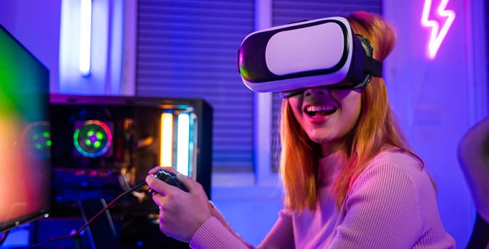 Gamer in VR headset glasses exploring metaverse play video game online with joystick on computer neon lights, Excited woman virtual playing gamepad controller she celebrating victory at home
