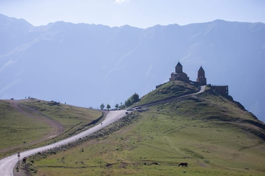 Close view of Holy Trinity Church in Kazbegi mountain range near Stepantsminda view Caucasus mountains in the background