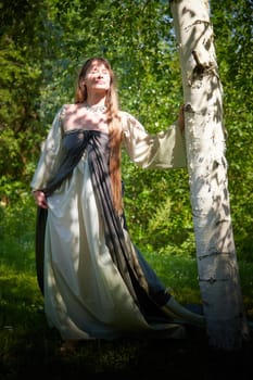 Beautiful dryad or fairy in nature. Pagan spirit of forest. Environmental friendliness, caring for nature. Adult mature woman 40-60 in Photo shoot