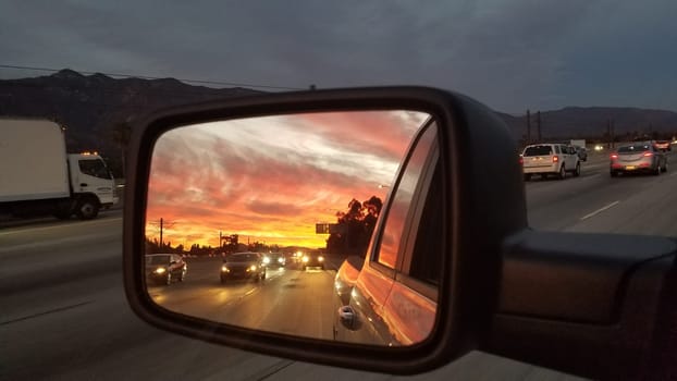 Sunset in the Rear View Mirror of a Pickup Truck on Freeway near Los Angeles. High quality photo