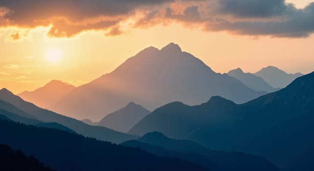 The mountains are covered in a blue sky with a sun setting in the background. The mountains are very tall and the sun is setting behind them
