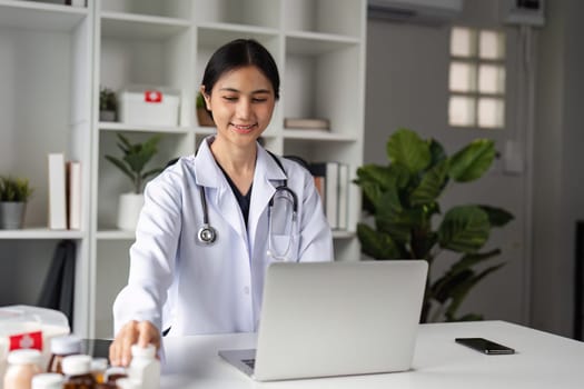 A confident female doctor in a white coat recommends medication during an online consultation in a modern medical office.