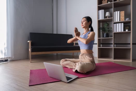 A woman practices yoga in a bright, modern living room, showcasing a peaceful and healthy lifestyle.