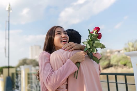 A joyful couple celebrates Valentine's Day with a heartfelt embrace in a picturesque city park symbolizing love.