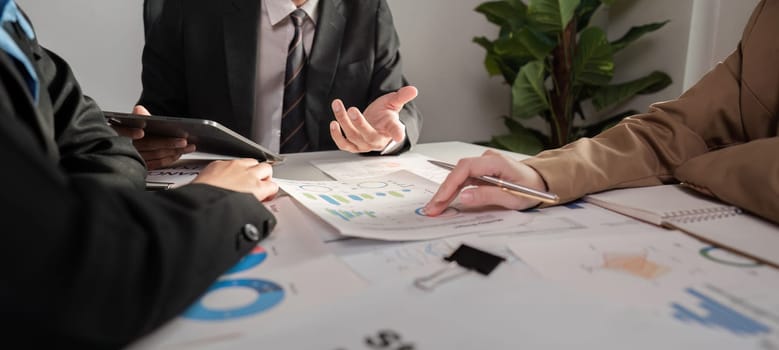Business team analyzing documents and discussing strategies in a modern office setting.