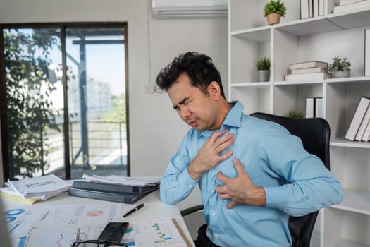 A businessman faces health issues stemming from hard work while managing stress in a contemporary office.