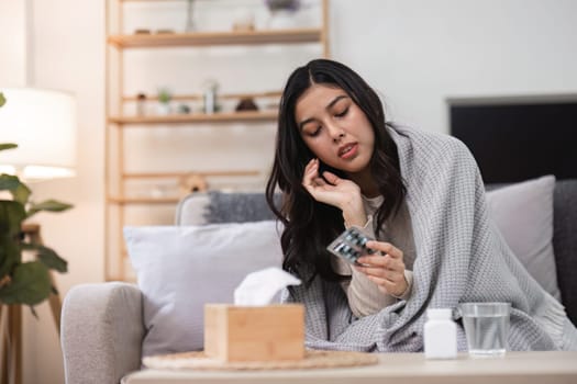 A woman feels unwell at home seeking comfort with remedies and care in a cozy environment.