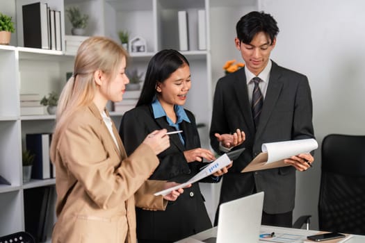 A diverse group of professionals engaged in a collaborative discussion, analyzing work plans in a contemporary office setting.
