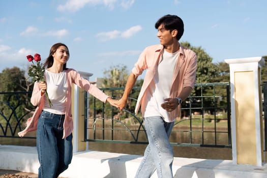 A couple joyfully walks hand in hand celebrating their love with a bouquet embodying the essence of Valentines Day.