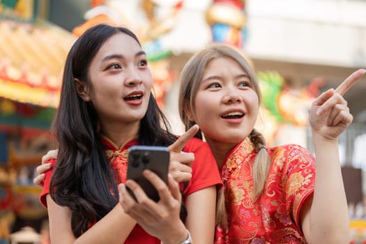 Two friends joyfully explore a vibrant market during the Chinese New Year festivities capturing the excitement.
