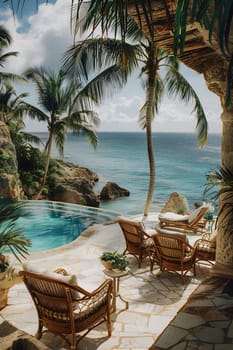 A charming patio with cozy chairs and a sparkling swimming pool offering breathtaking views of the azure ocean. Surrounded by nature, including lush trees and plants, its the perfect outdoor retreat