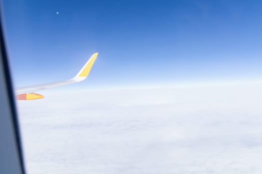 View from airplane window of blue sky with clouds. High quality photo