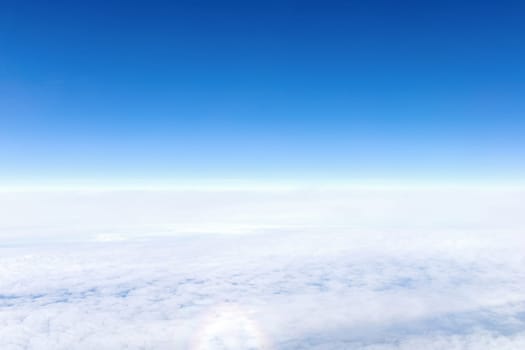 View from airplane window of blue sky with clouds. High quality photo