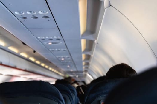 Inside the passenger plane cabin with people. Airplane travel concept.