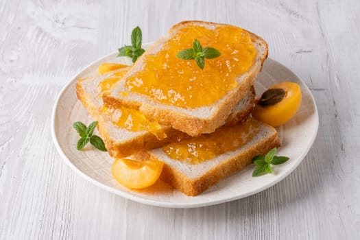 Delicious slices of bread topped with sweet orange marmalade and garnished with mint leaves.