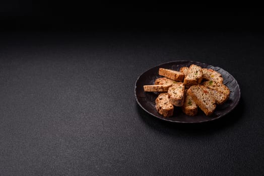 Freshly baked Italian cantuccini cookies with nuts and candied fruits on dark concrete background