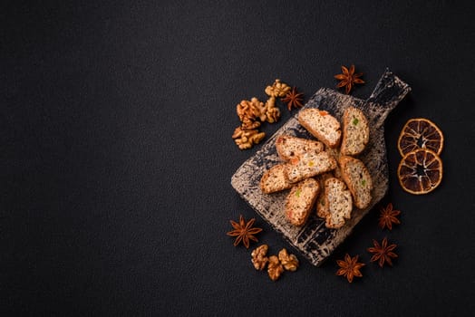 Freshly baked Italian cantuccini cookies with nuts and candied fruits on dark concrete background