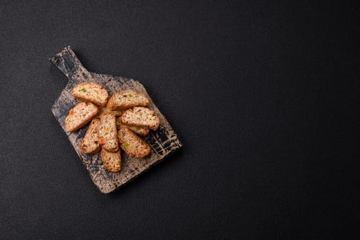 Freshly baked Italian cantuccini cookies with nuts and candied fruits on dark concrete background