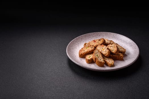 Freshly baked Italian cantuccini cookies with nuts and candied fruits on dark concrete background