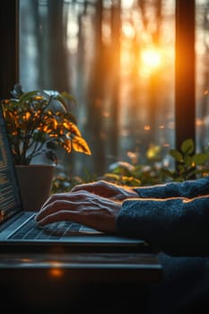 Close-up of a man's hand typing on a keyboard in the background of the sunset outside the window. Writing a letter on a laptop keyboard.