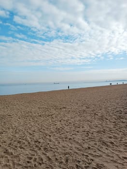 people walk Baltic north blue sea horizon cloudy day ship boat sand beach winter autumn season cold. High quality photo