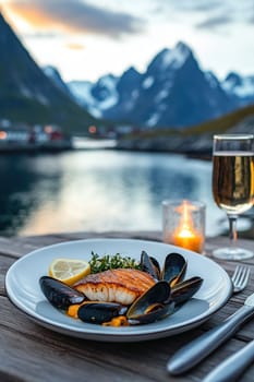 Close-up of fillet of sea fish and mussels in a plate on a table on the background of mountains.