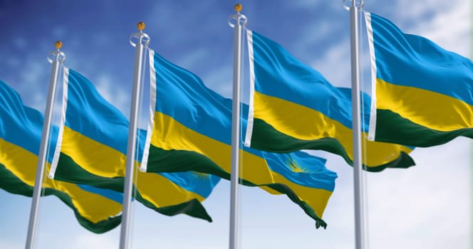 Rwanda national flags waving on a clear day. Three horizontal bands: blue, yellow, green with 24 rays yellow sun. 3d illustration render. Selective focus