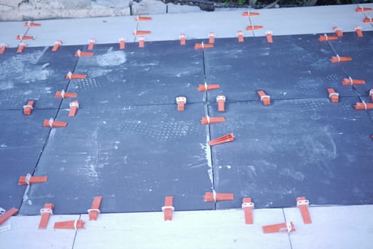 A detailed view of tile installation using spacers for precise alignment throughout the project