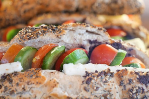 Indulge in a delicious sandwich that is generously filled with fresh vegetables and savory cheese