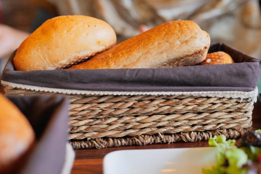 A beautifully arranged array of colorful artisan bread rolls sitting neatly in a woven basket