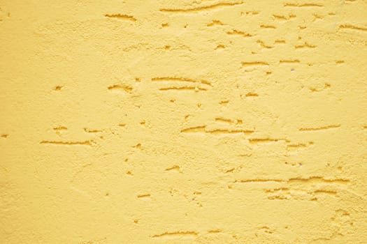A closeup view of a beautifully textured yellow wall showcasing its unique and intricate patterns