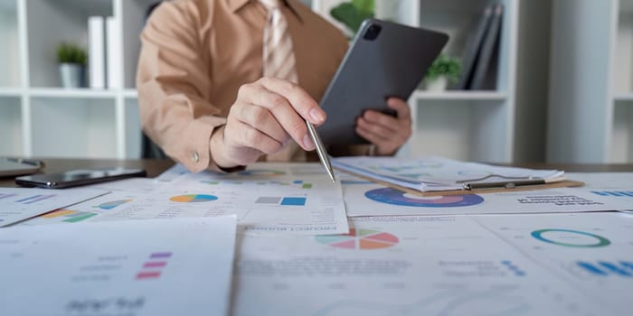 A professional reviewing digital reports during a business meeting focused on analytics and strategy discussions.