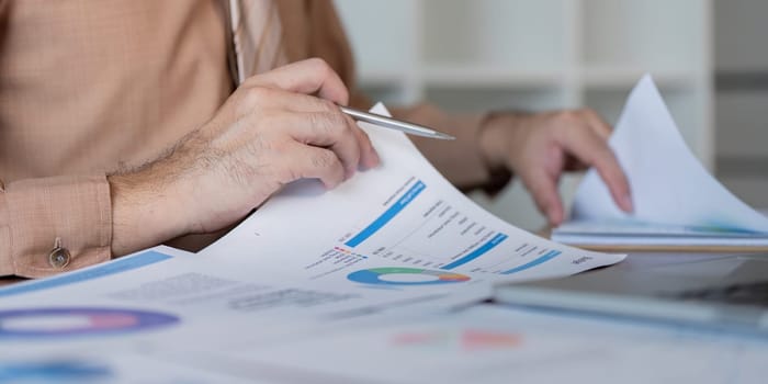 A professional reviews financial reports analyzing important business metrics for strategic decision-making.