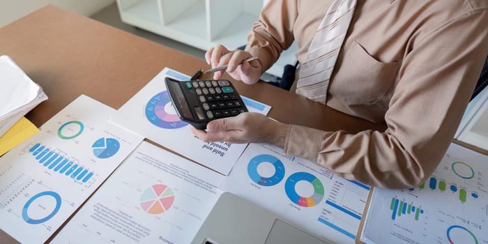 Analyzing financial data with charts and reports to guide business decisions in a professional office environment.