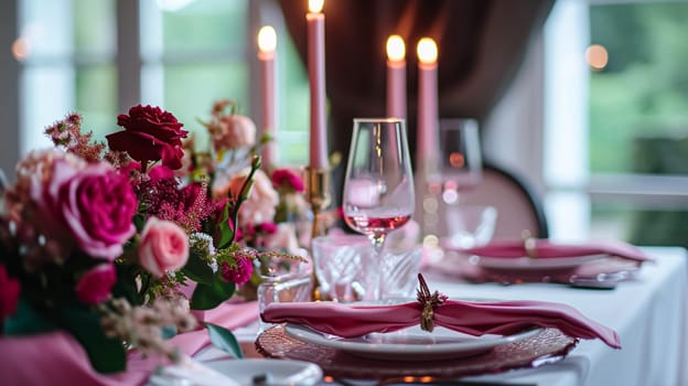 Festive table setting with candles and arrangement of beautiful red flowers. Holiday concept. High quality photo