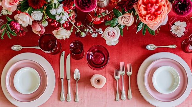 Festive table setting with candles and arrangement of beautiful red flowers. Holiday concept. High quality photo