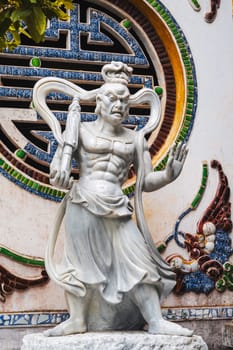statue of a Buddhist deity at the entrance to a temple on a pagoda in Vietnam