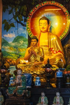 An altar with a golden Buddha in a pagoda on the marble mountains of Da Nang