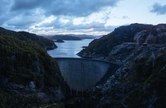 An aerial view of the Gordon Dam on a cool summer's day. It is a unique double curvature concrete arch dam with a spillway across the Gordon River near Strathgordon, South West Tasmania, Australia