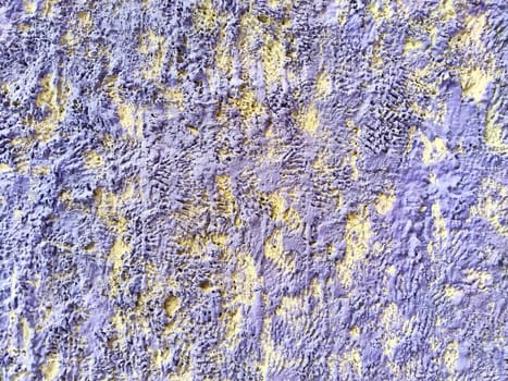 A detailed view of a textured wall featuring vibrant yellow and gray hues, perfect for backgrounds or artistic applications.