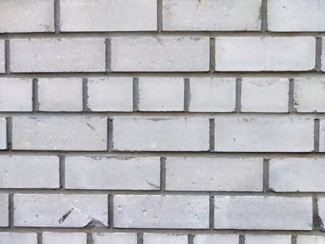 A gray brick wall featuring a uniform arrangement and texture, ideal for architectural projects.